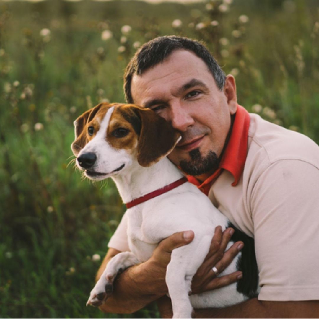 happy man cuddling jack russell terrier